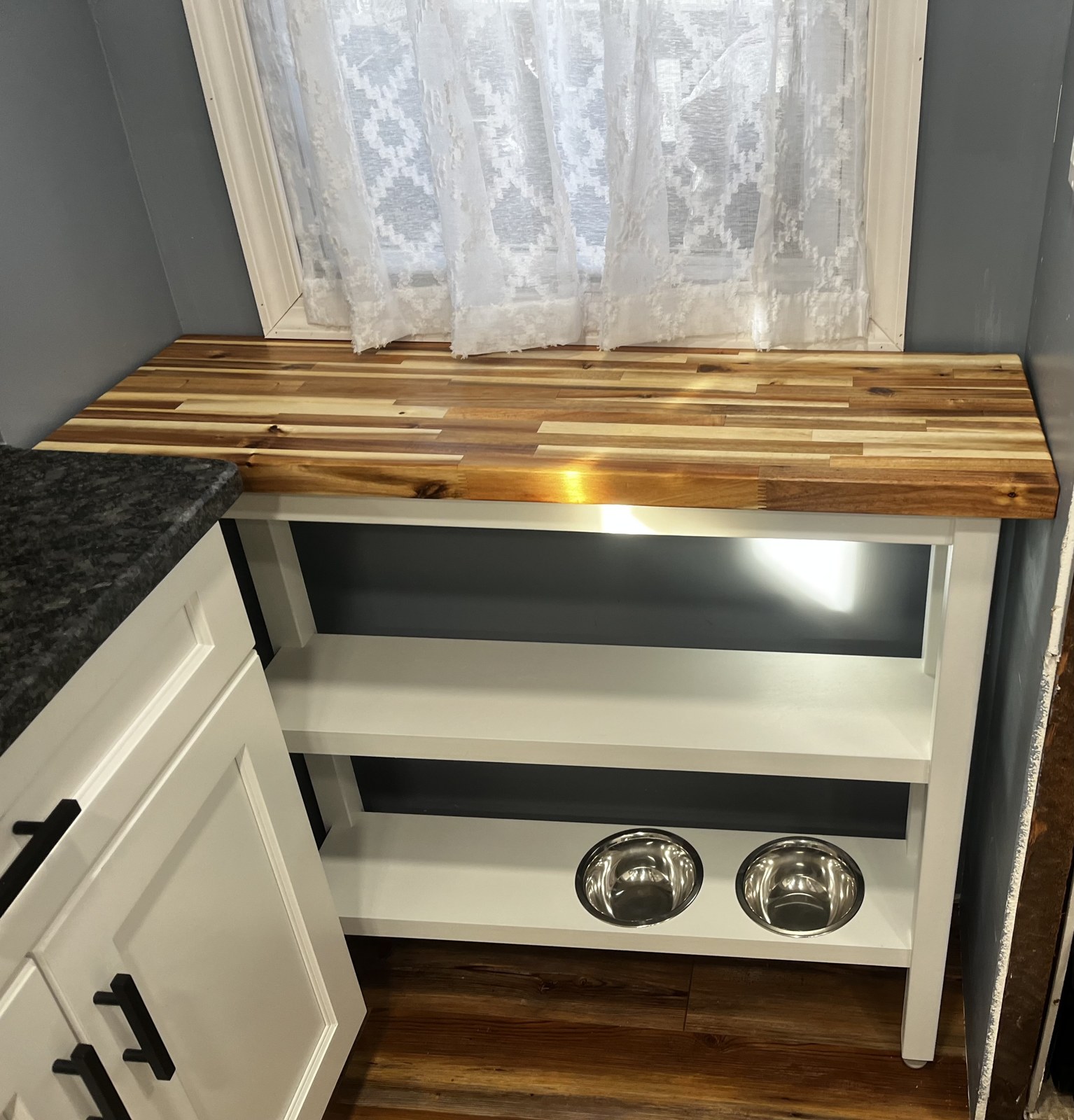 White custom shelving with a wood top and inset pet bowls